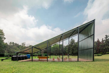 Agora de agua, de lámina de aluminio en medio de un espacio verde